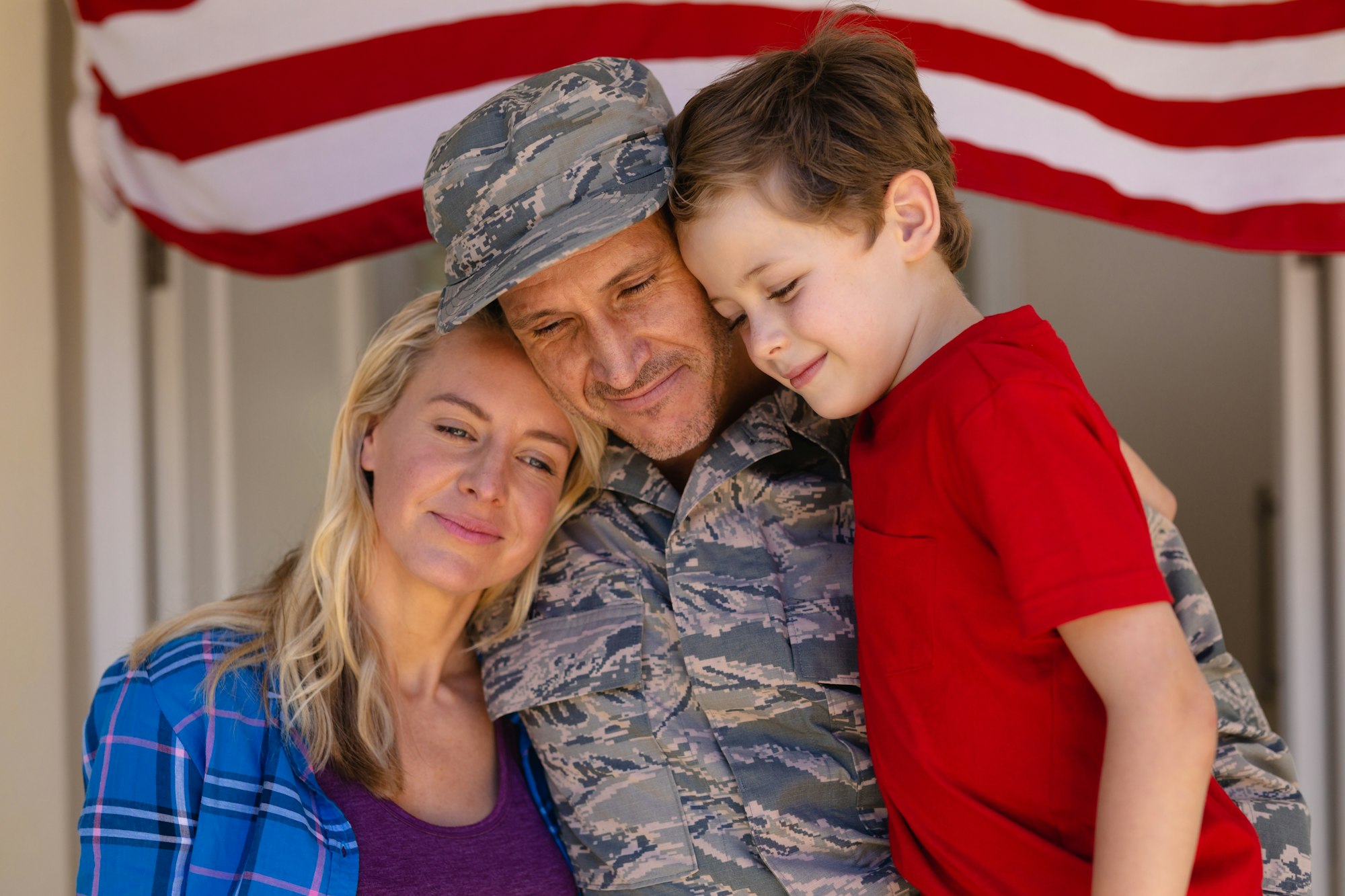 Caucasian family with military man standing entrance of house